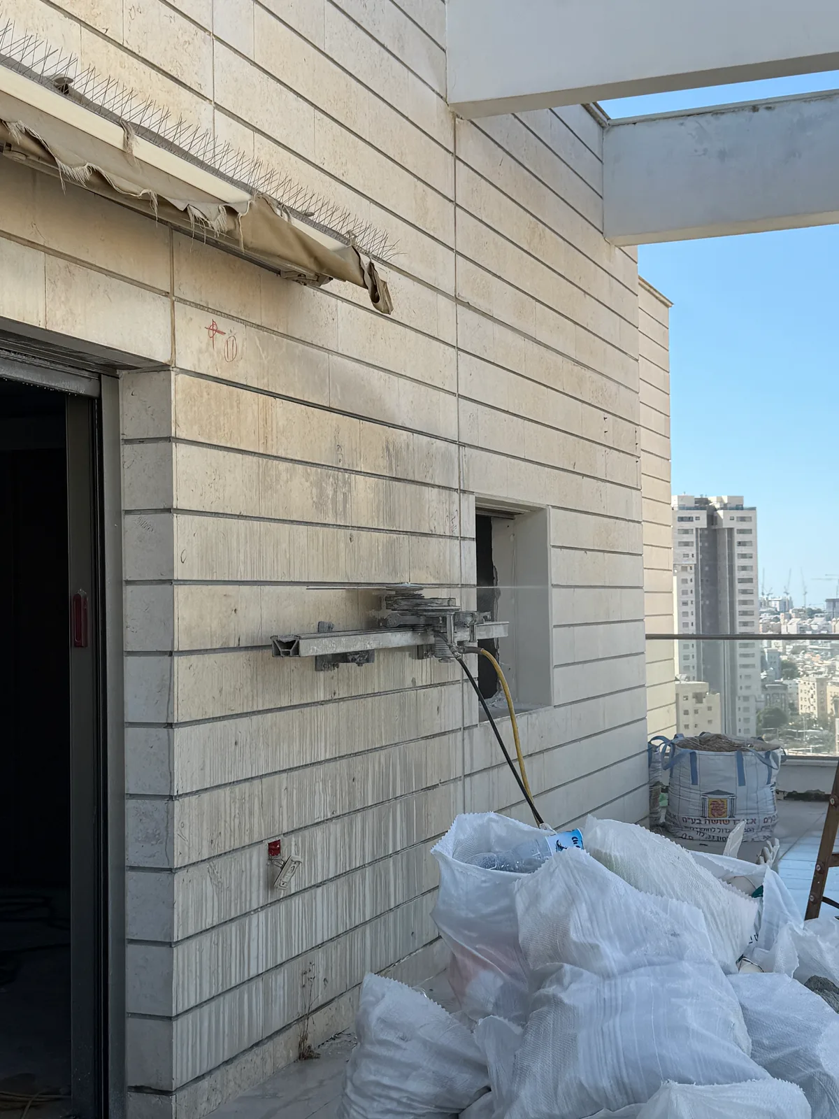 מסור קיר על מסילה במהלך פתיחת ויטרינה בפנטהאוז בחולון