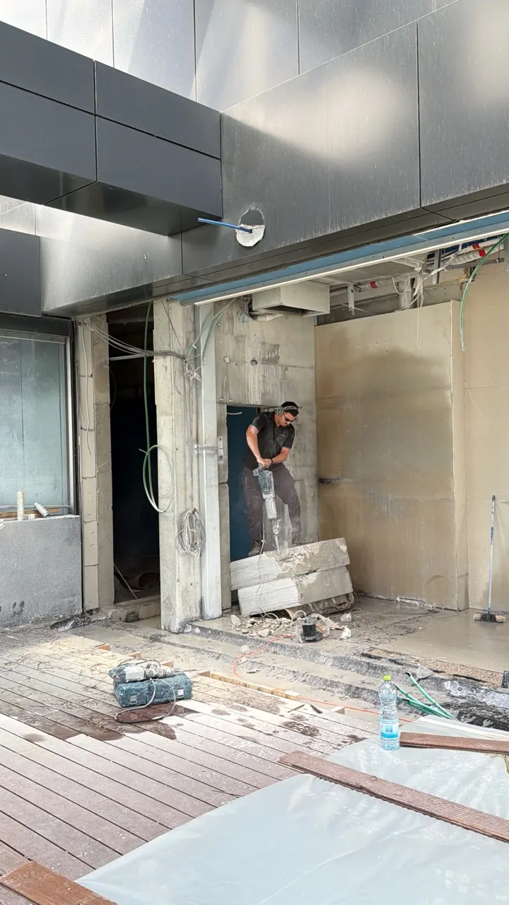 איש צוות מפרק מקטע בטון לאחר ניסור העמוד