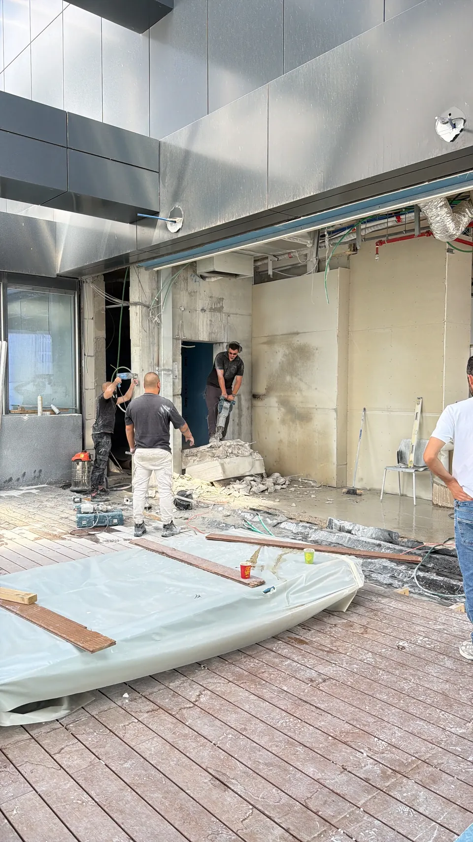 שלושה אנשי צוות מפרקים מקטע בטון בפנטהאוז